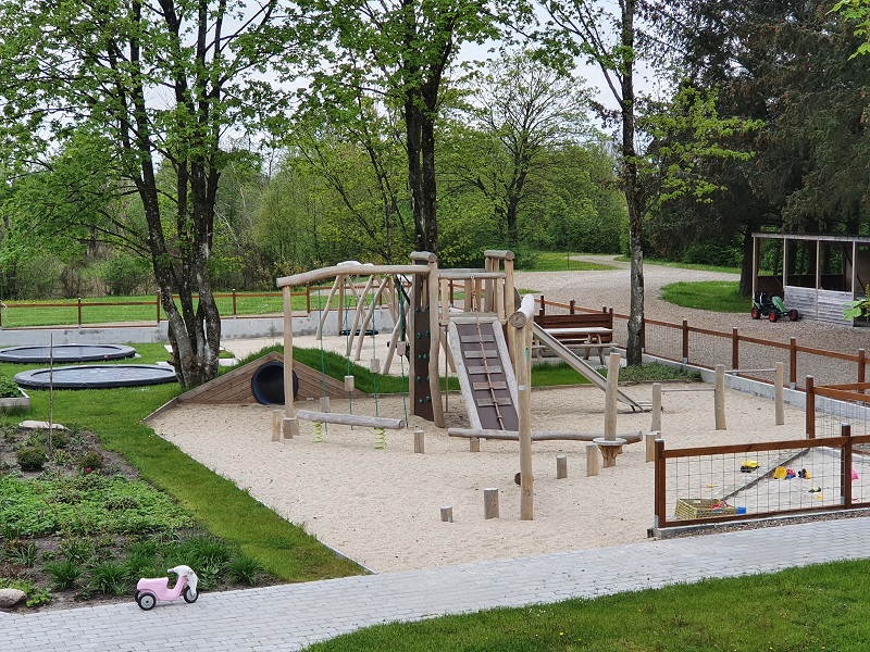 Stor legeplads med klatretårn, balancebomme, gynger og trampoliner på overnatningssted ved Billund