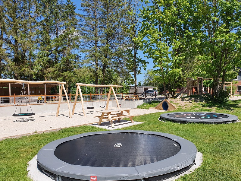 Stor legeplads med trampoliner, gynger, bord/bænkesæt og klatretårn